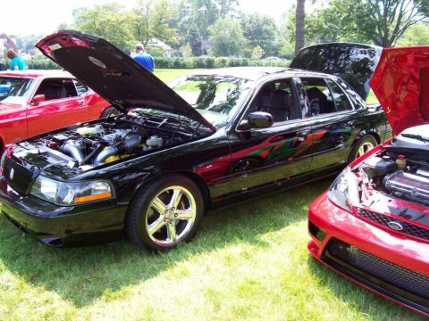 2003 Mercury Marauder - A black 2003 Mercury Marauder is displayed with its hood open, alongside other vehicles at an outdoor car show.