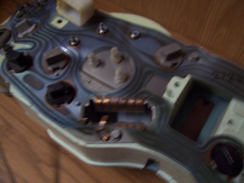 Back of a car's dashboard instrument cluster with exposed wiring and connectors