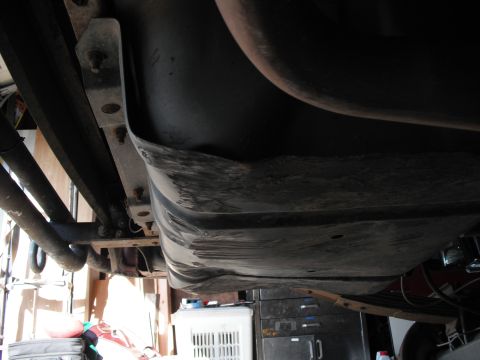 1991 Ford Bronco - Underside view of a vehicle's fuel tank and frame rails, showing some wear and tear.