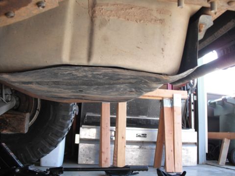 1991 Ford Bronco - The vehicle's fuel tank is visible from below, supported by sawhorses during maintenance.
