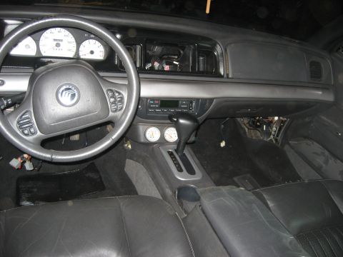 1999 Ford Crown Victoria - Grey interior of a Mercury sedan mid-project, shot from the rear seat: Mercury-badged airbag steering wheel, white-face gauge cluster, two…