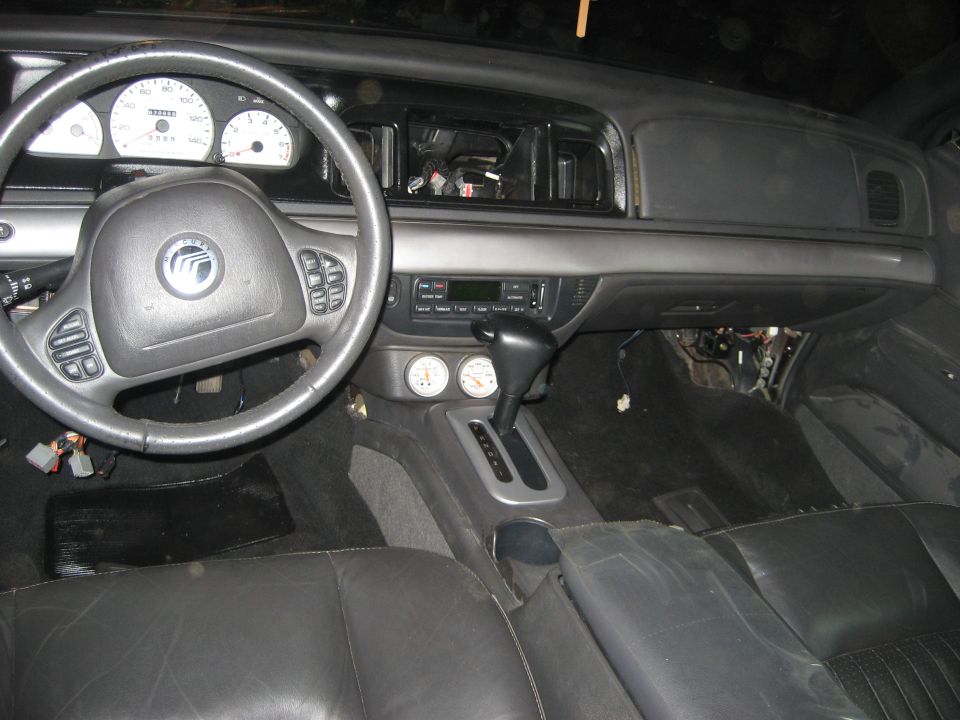 Mercury sedan interior with white gauges, floor shifter, radio removed and wiring exposed