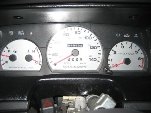 1999 Ford Crown Victoria - Instrument cluster with white faces reading 070995 miles on the mechanical odometer, a 140 mph speedometer lettered MARAUDER at the bottom,…