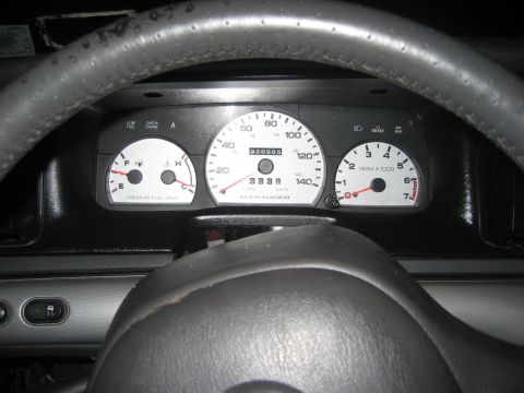 1999 Ford Crown Victoria - Instrument cluster viewed through a gray leather-wrapped steering wheel, showing a 140 mph speedometer marked MARAUDER, a 7,000 rpm tachome…
