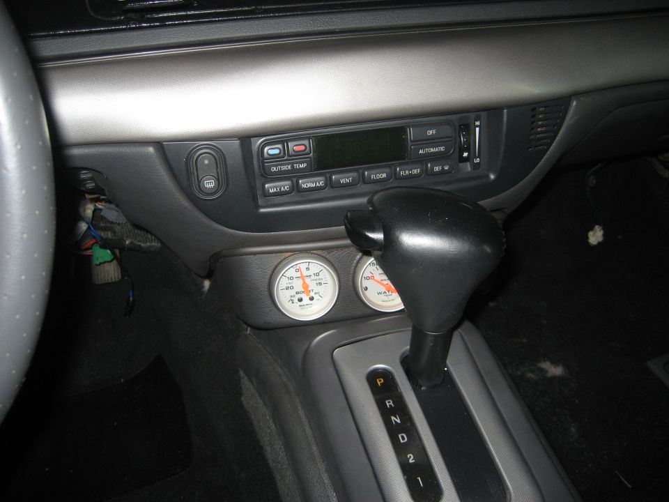 Center console with HVAC controls, two aftermarket gauges and automatic shifter