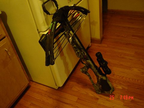 2004 Jeep Wrangler - A crossbow with a scope and arrows is shown indoors.