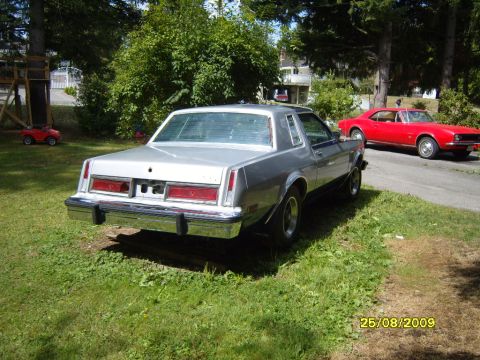 1989 Ford Bronco - A silver coupe sits in a grassy yard next to a red sports car, with a date stamp of 25/08/2009.