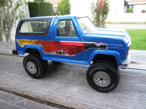 1986 Ford Bronco - This blue toy SUV features prominent eagle graphics and 'Eagle Run 4x4' branding on its side.