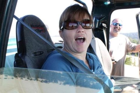 1979 Ford Bronco - A woman with her mouth open and sunglasses on is in the driver's seat of a 1979 Ford Bronco, with a man standing outside.