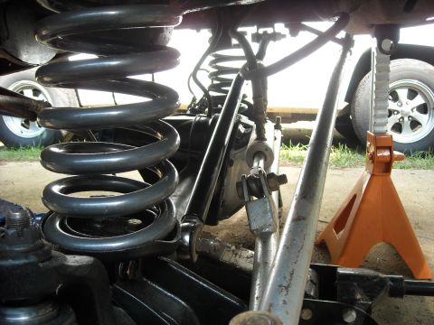 1979 Ford F-150 - Truck suspension components, including a coil spring and shock, are visible with a jack stand providing support.
