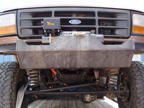 1993 Ford Bronco - Front view of a brown Ford truck with a winch mounted behind a custom bumper.