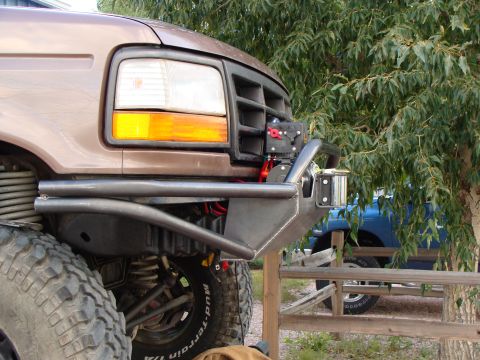 1993 Ford Bronco - Custom bumper and winch on a 1993 Ford Bronco, with a blue truck visible in the background.