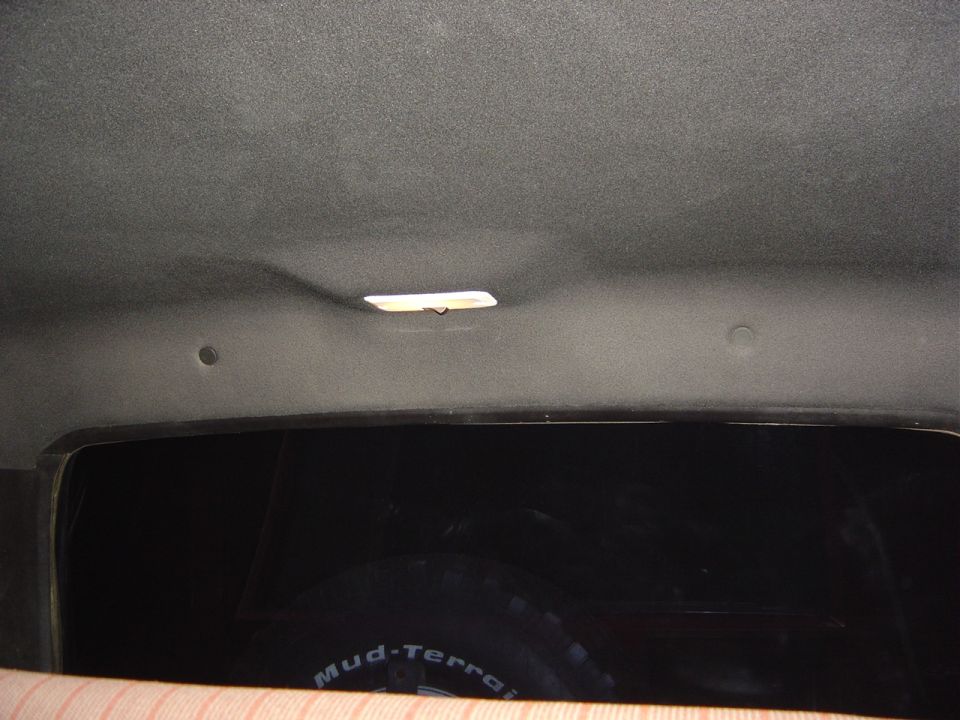 Drilled holes in the inner top and installed trim push tabs. Note the light is on and is now wired int the Bronco with a disconect for when the top is removed.