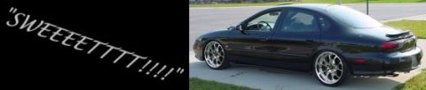 1999 Ford Taurus - A black sedan with custom rims is parked on a driveway.