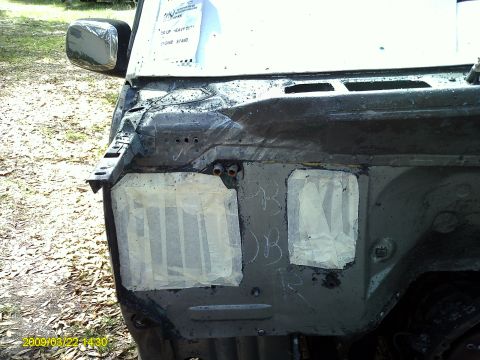1992 Ford Bronco - The front section of a vehicle shows areas covered with tape and chalk markings.