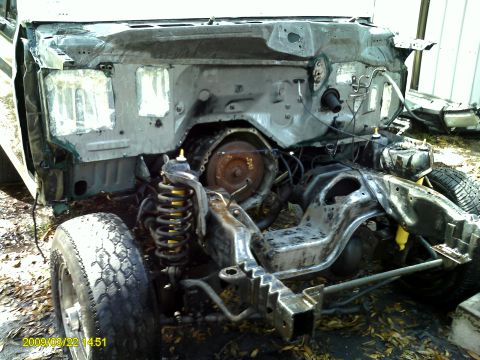 1992 Ford Bronco - The front end of a vehicle is disassembled, showing the engine, transmission, and suspension parts.