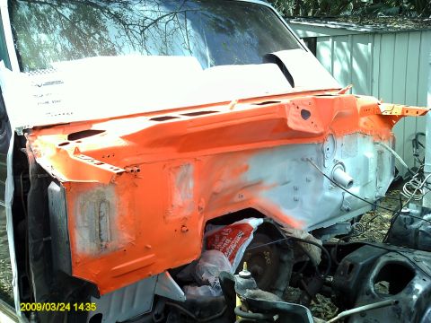 1992 Ford Bronco - The engine bay of a vehicle is shown with orange primer applied to the firewall and surrounding areas.