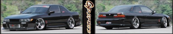 Black coupe with aftermarket body kit and wheels, front 3/4 view
