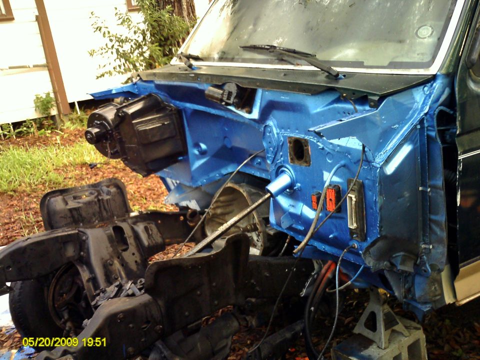 Vehicle firewall painted blue, with chassis and engine components visible. Date stamp 05/20/2009
