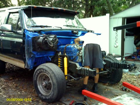 1992 Ford Bronco - Front end of a 1992 Ford Bronco disassembled for repair, showing the engine and suspension components.