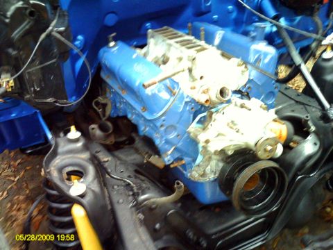1992 Ford Bronco - Close-up view of an engine bay, a blue-painted engine and various mechanical components.