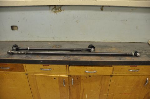 1996 Ford Bronco - Steering linkage components are laid out on a workbench.