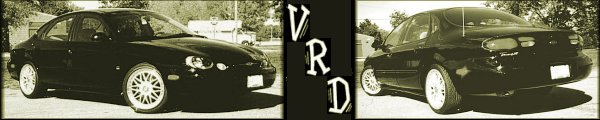 Black 1999 Ford Taurus, front 3/4 view. Aftermarket wheels