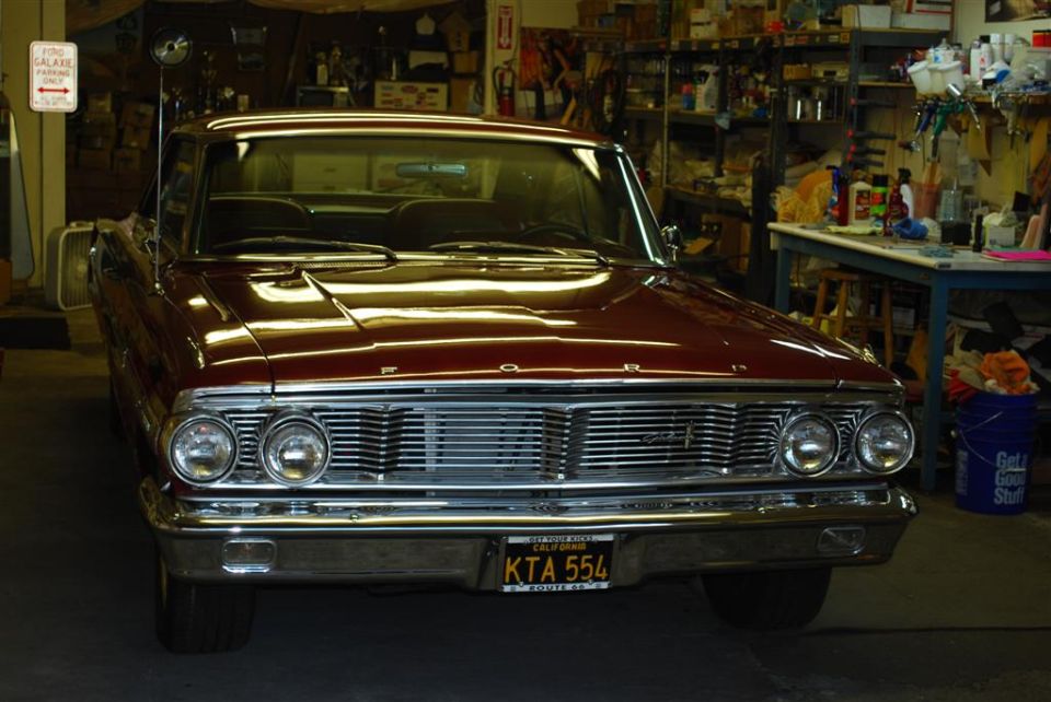 Front view of a maroon 1963 Ford Galaxie parked in a garage. License plate reads KTA 554