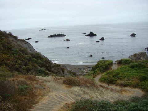 1989 Ford Bronco - Coastal landscape with ocean, rocks, and a walking path.