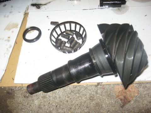 1995 Ford Bronco - Differential pinion gear and associated parts laid out on a workbench.