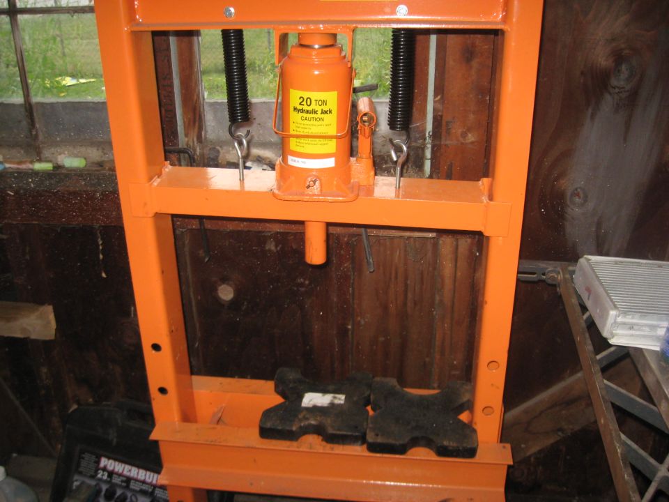Orange hydraulic press with 20 ton jack and caution label