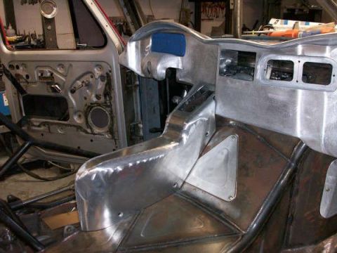 1986 Ford Bronco - Interior of a vehicle undergoing custom fabrication, a roll cage and bare metal construction.