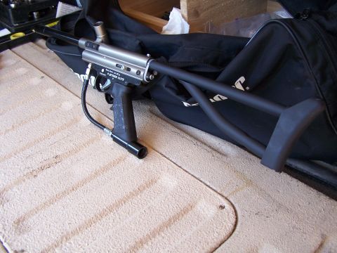 1986 Ford Bronco - A paintball gun is placed on a textured surface next to a black bag.