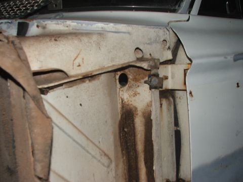 1963 Ford Fairlane - Close-up view of the inner fender and frame of a car, showing signs of rust and dirt.