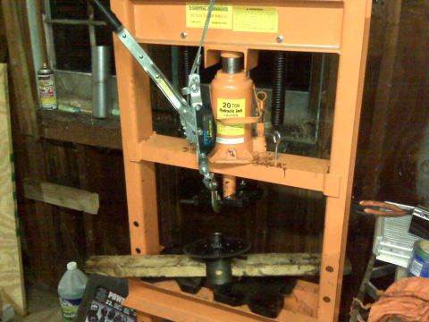 1995 Ford Bronco - A hydraulic press is being used to work on a vehicle component, with a 20-ton jack overhead.