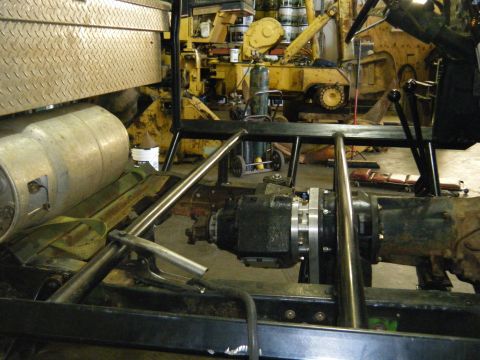 1978 Ford Bronco - The interior of a vehicle chassis reveals its drivetrain components, including the transmission and transfer case.