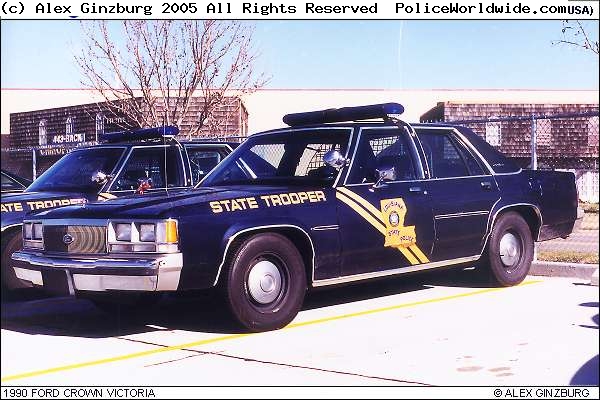 Louisiana State Trooper car parked next to another trooper car. It has 'STATE TROOPER' on the door