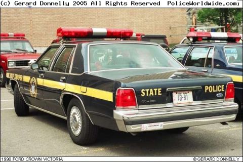1991 Ford LTD Crown Victoria - A 1990 Ford Crown Victoria police car is seen from the rear, parked next to another vehicle.