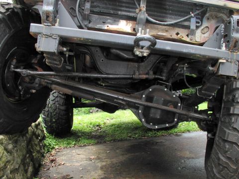 1986 Ford Bronco - Close-up view of the undercarriage and suspension of a modified 4x4 vehicle, showing its robust construction.
