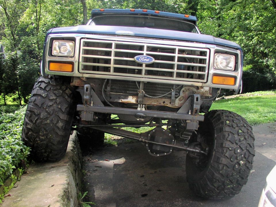 Front view of a lifted blue 1986 Ford Bronco with large off-road tires