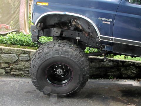 1986 Ford Bronco - Close-up of a blue 1986 Ford Bronco showing its front fender and large tire.