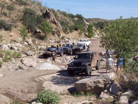 1981 Ford F-150 - A group of Jeeps and a pickup truck navigate a challenging off-road trail.