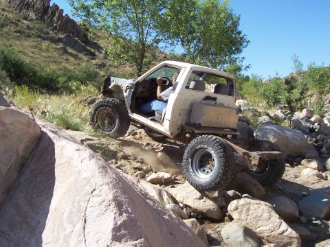 1981 Ford F-150 - This heavily modified off-road vehicle navigates a challenging rocky trail, its capabilities.