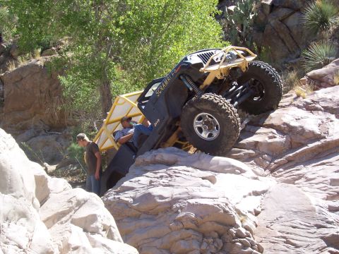 1981 Ford F-150 - A Jeep CJ-8 Scrambler navigates a rocky off-road course, its roll cage visible.