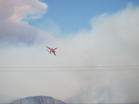 1990 Ford Bronco - An airplane flies over a smoky landscape, likely during a wildfire event.