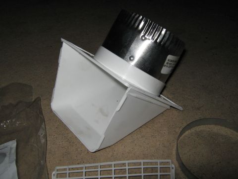 2000 Mercury Grand Marquis - A white plastic duct elbow is connected to a silver metal duct connector, lying on a textured surface.