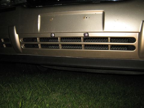 2000 Mercury Grand Marquis - Close-up of the front grille and bumper of a gold 2000 Mercury Grand Marquis.