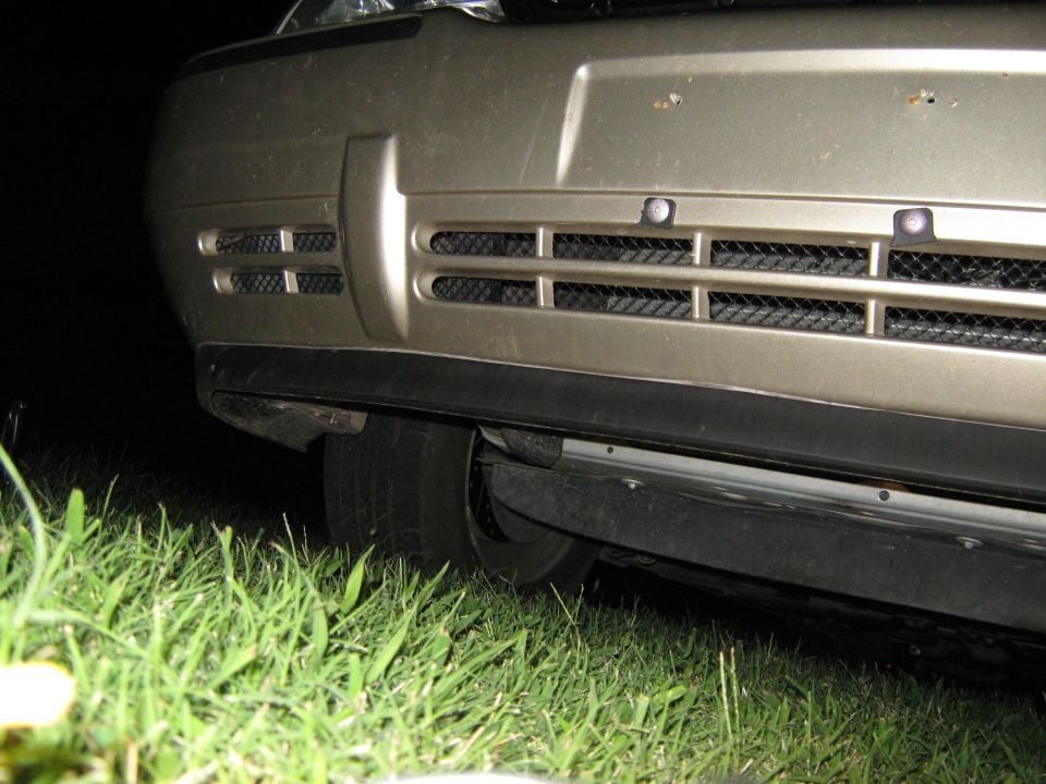 Front bumper and grille of a car, with grass in the foreground