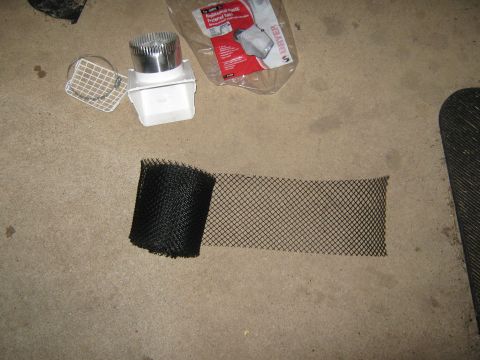 2000 Mercury Grand Marquis - Various dryer vent components and a roll of black mesh are laid out on a concrete surface.
