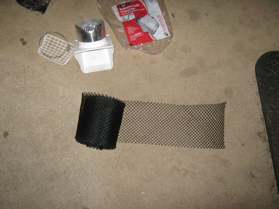 Dryer vent parts and black mesh on concrete floor